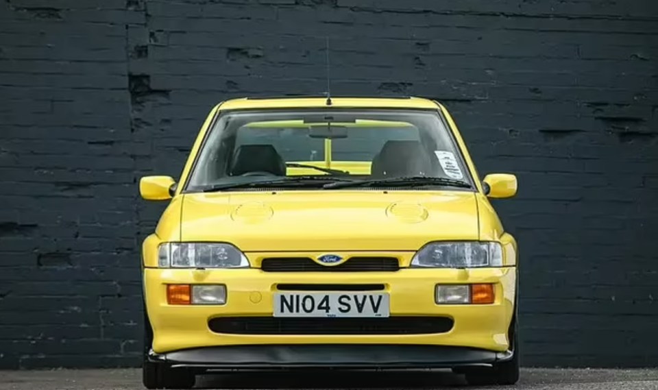 a yellow ford car with a license plate that says ni04 svv