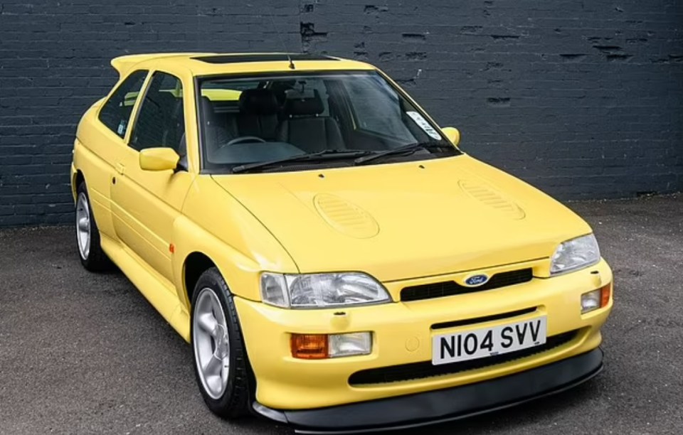 a yellow ford car with a license plate that says ni04 svv