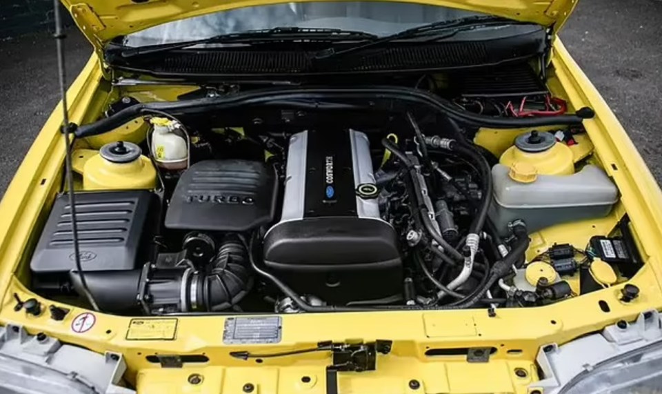 the engine of a yellow car with the hood open