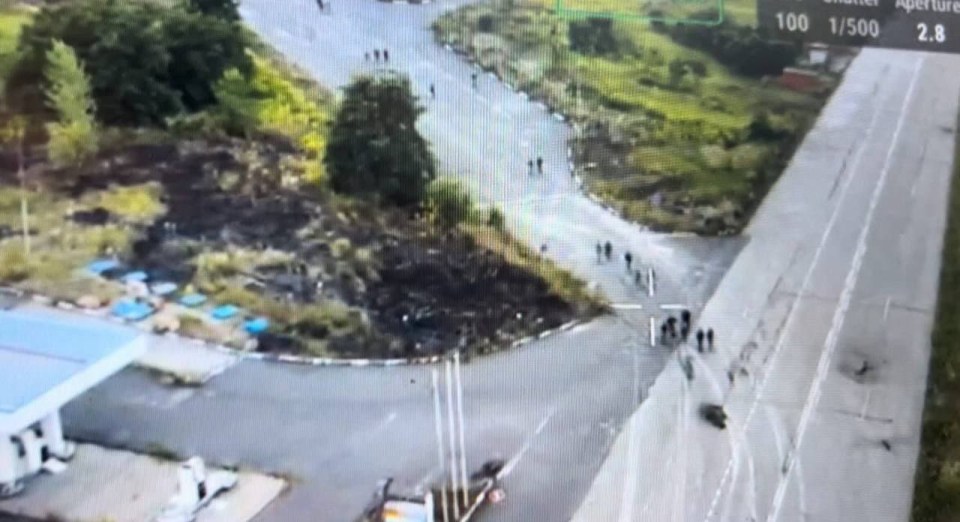 a group of people are walking down a road .