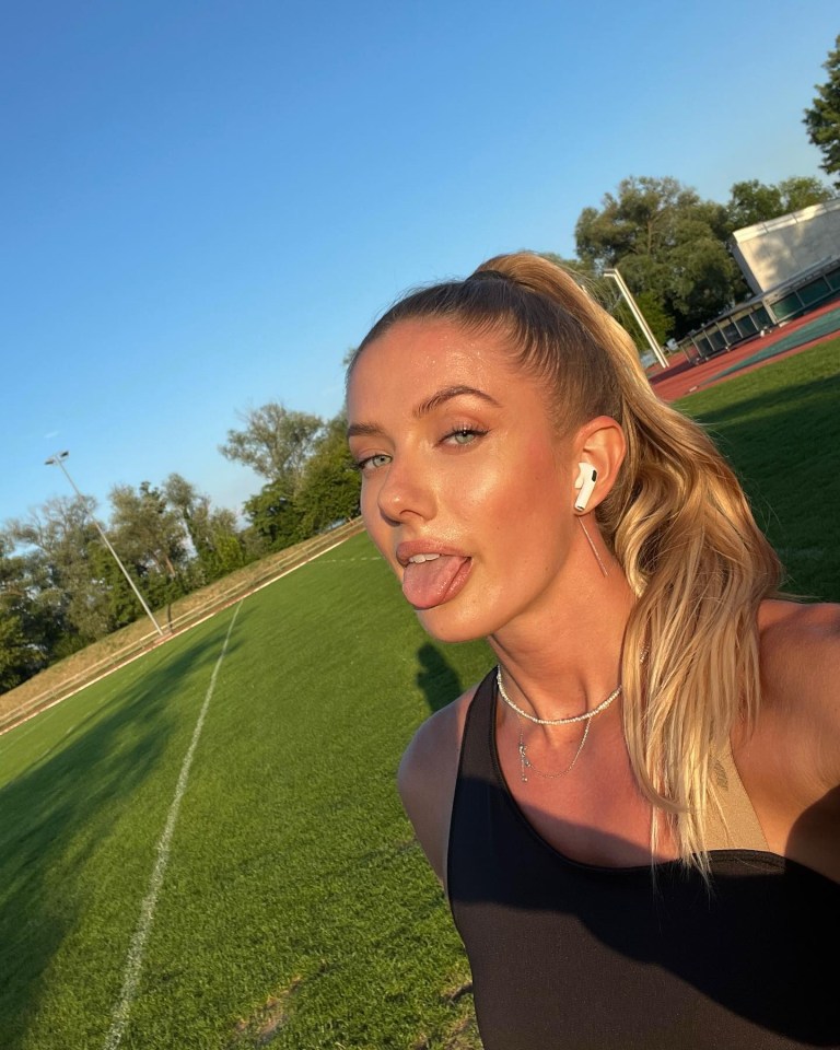 a woman is sticking her tongue out in front of a field