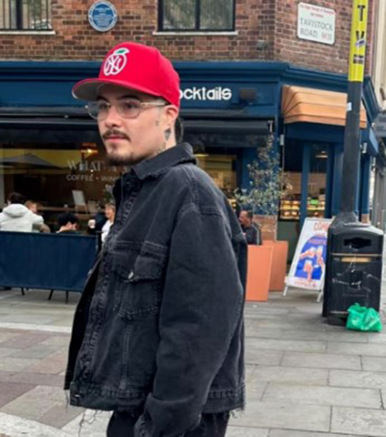 a man wearing a red hat is standing in front of a restaurant called cocktails