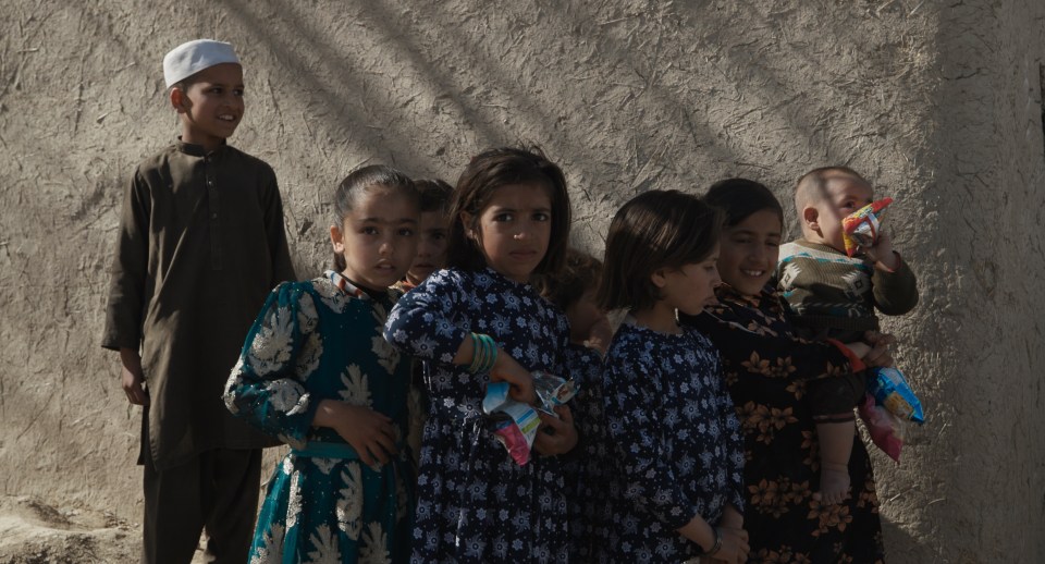 a group of children standing in front of a wall