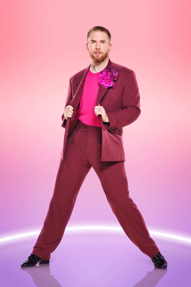 a man in a pink suit has a flower in his lapel