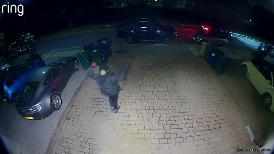 A thief can be seen attempting to steal an Aston Martin by cloning the key