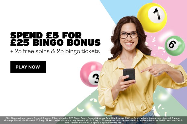 a woman holding a cell phone in front of a sign that says spend £ 5 for £ 25 bingo bonus