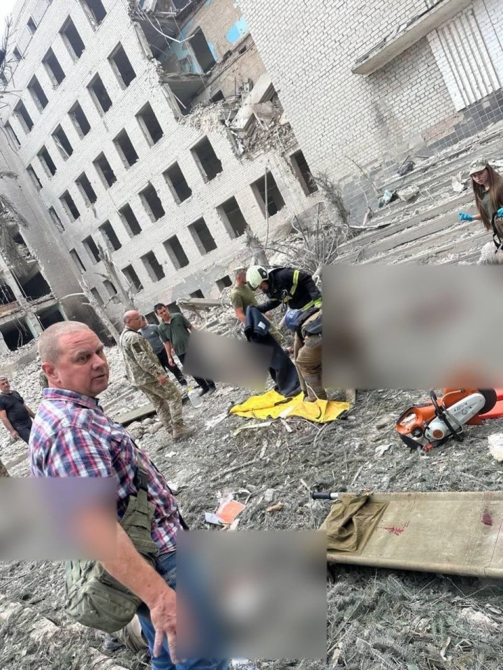 a man in a plaid shirt stands in front of a building that has fallen