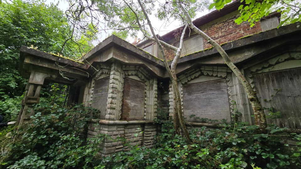 a brick building with a roof that has moss on it