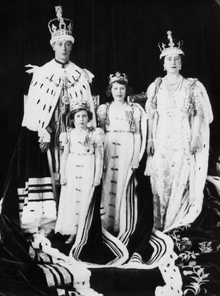 a black and white photo of a family wearing crowns