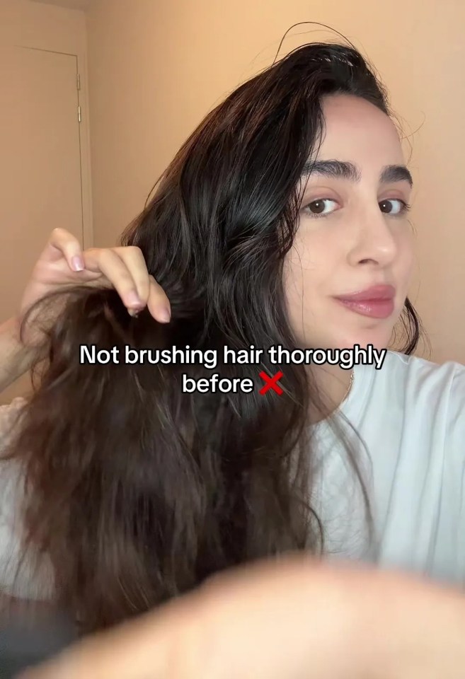 a woman brushes her hair with a caption that says " not brushing hair thoroughly before "