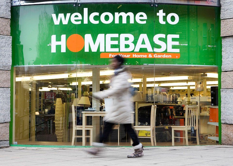 a woman walks past a store called homebase