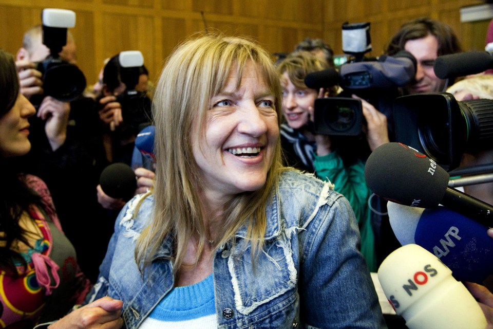 a woman is surrounded by microphones including one that says nos