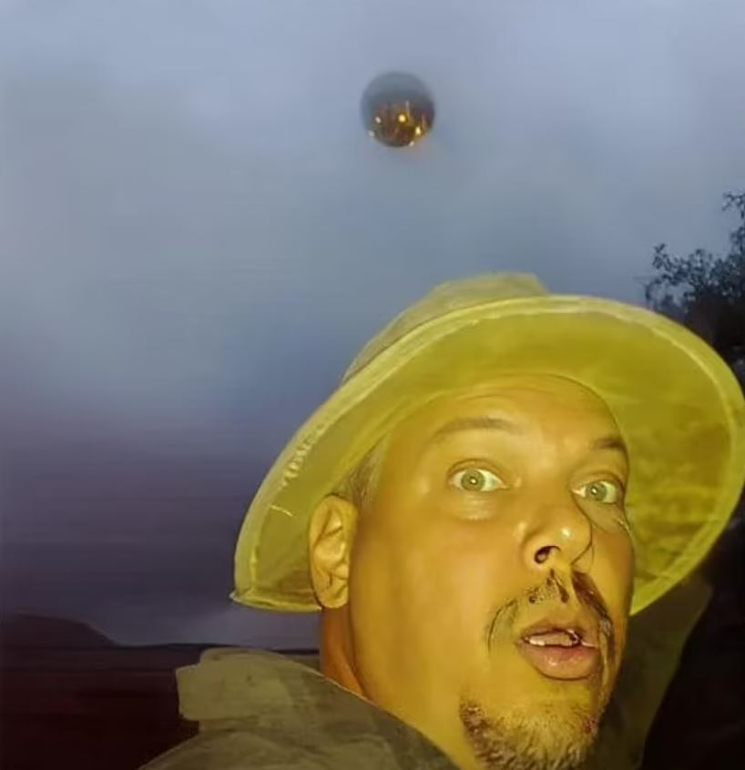 a man wearing a yellow hat is looking at something in the sky