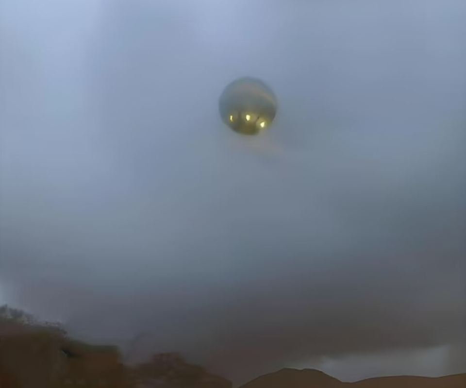 a hot air balloon is flying through a foggy sky