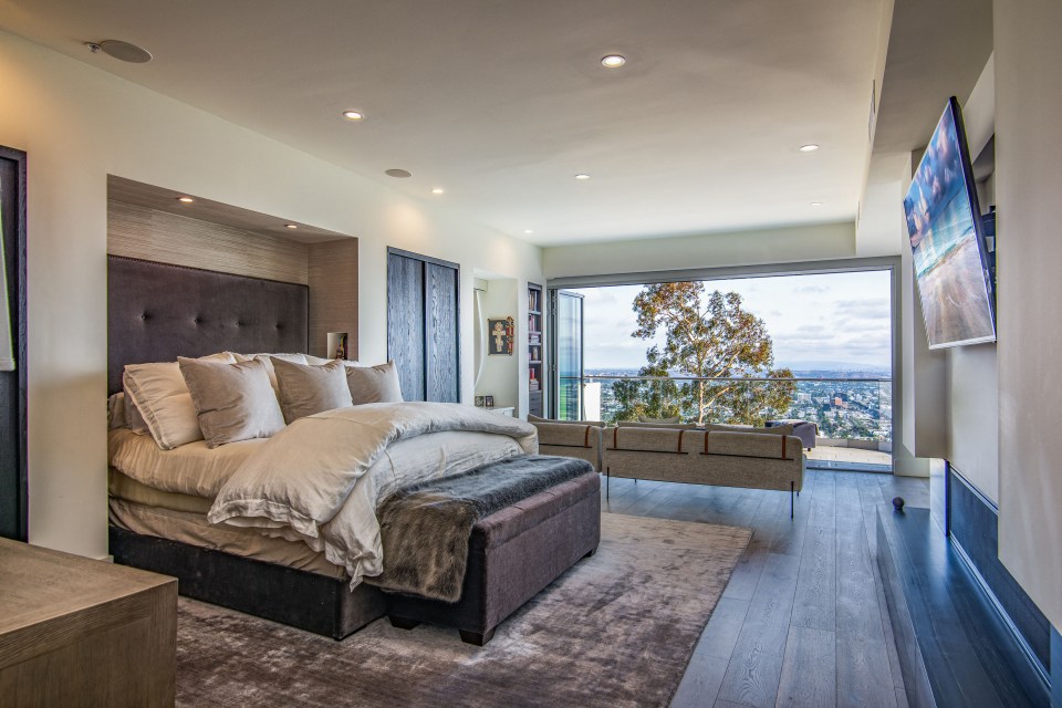 Her bedroom is flooded by light from the floor-to-ceiling windows and the bed comes with custom nooks in the walls