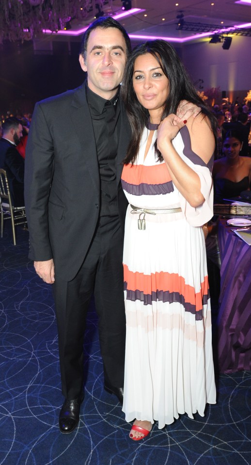 a man in a suit and a woman in a dress pose for a picture