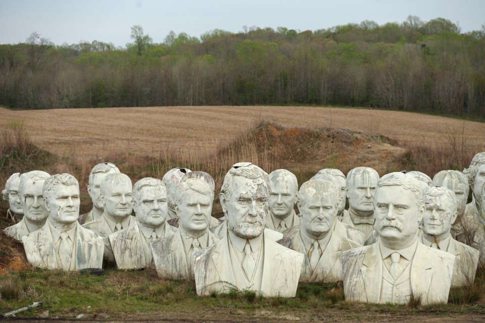 a bunch of busts of presidents are in a field