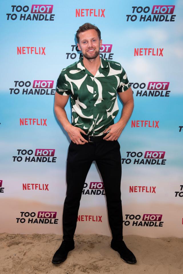 a man stands in front of a hot ndle sign