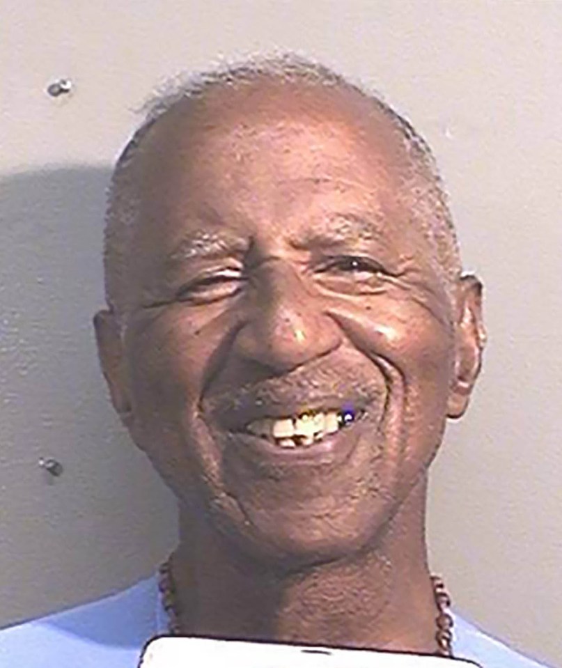 a man is smiling and holding a cell phone in his hand .