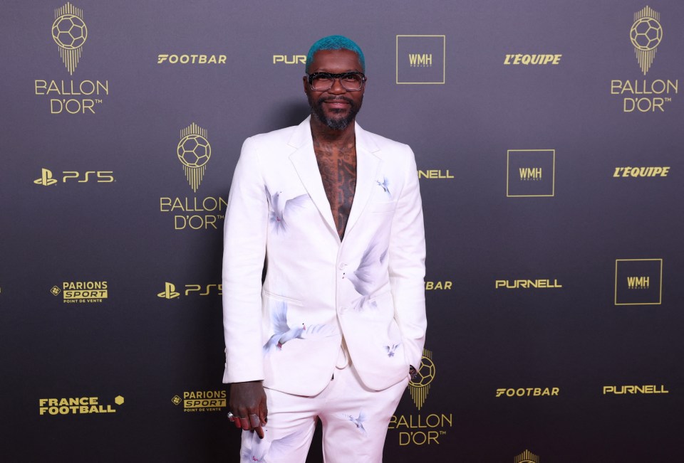 a man in a white suit stands in front of a wall that says ballon d' or