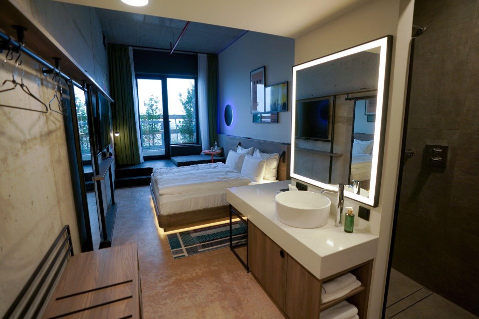 a hotel room with two beds and a sink