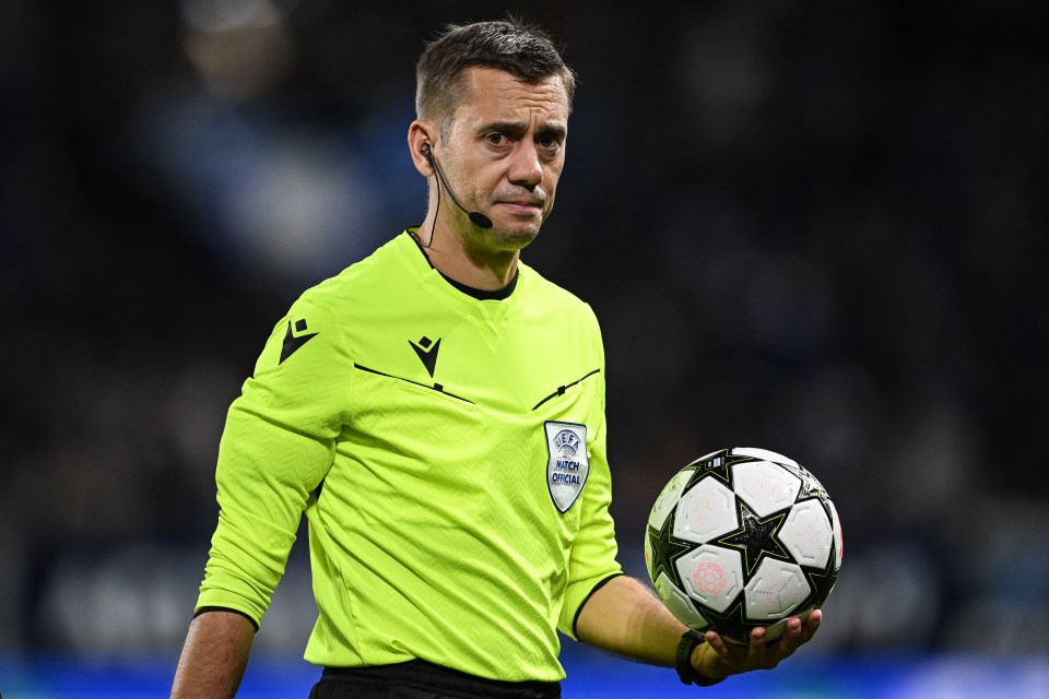 a referee is holding a soccer ball with the word uefa on it