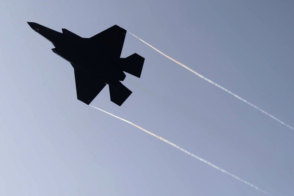 a fighter jet is flying through a clear blue sky