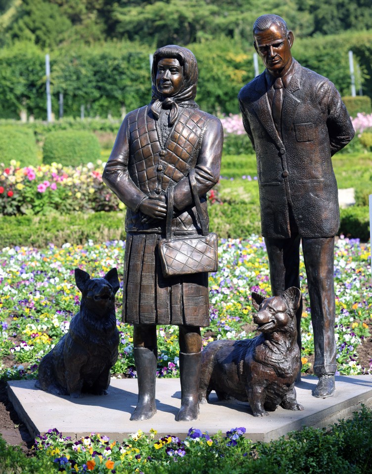 a statue of a man and woman standing next to two dogs