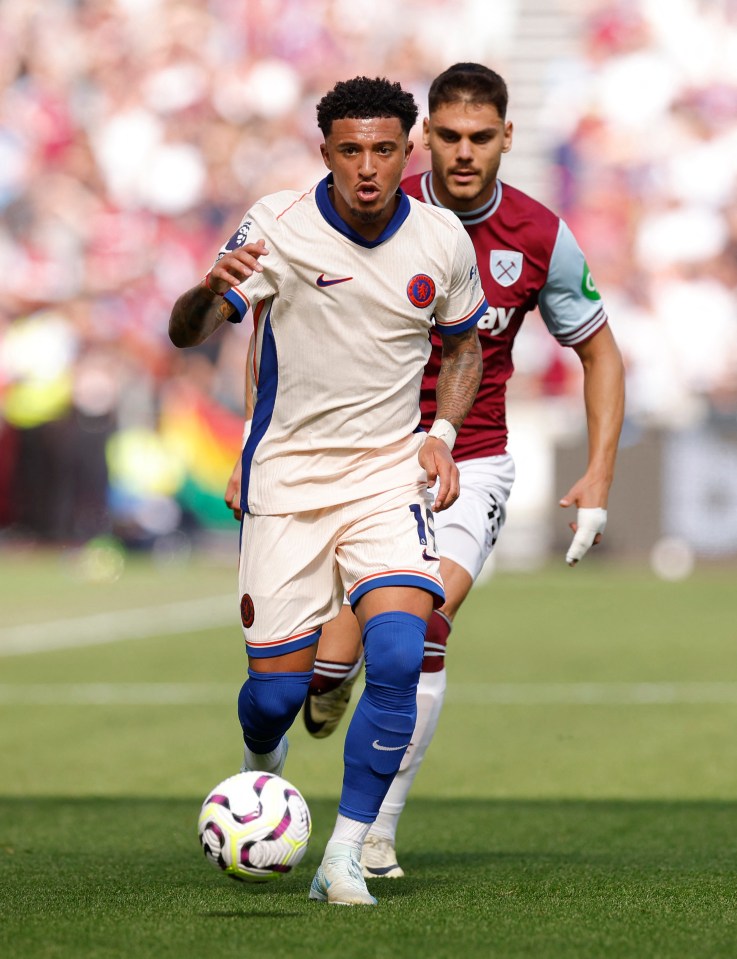 a soccer player wearing a white nike jersey runs with the ball