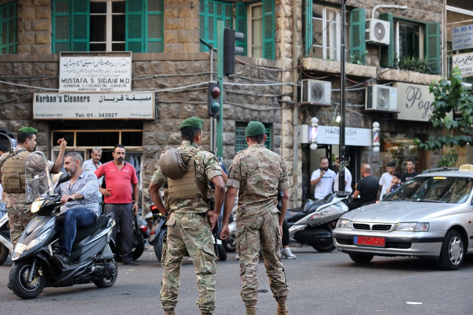 two soldiers stand in front of a building that says mustafa s. sudan md