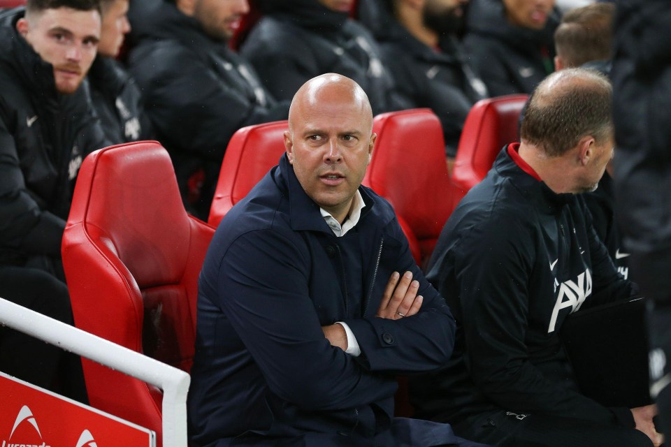 a man sitting in a soccer stadium with a sign that says ' allianz ' on it