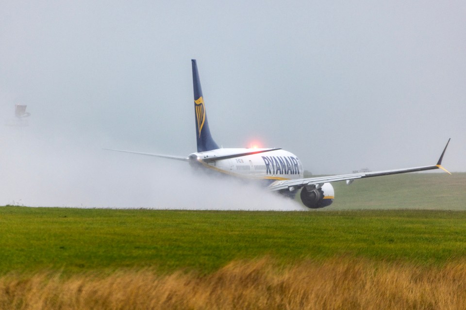 a ryanair plane is taking off from a grassy field