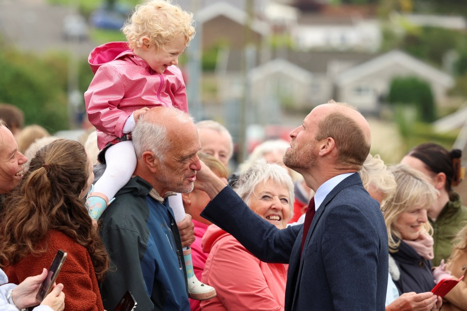 a man in a suit is holding a little girl in his arms