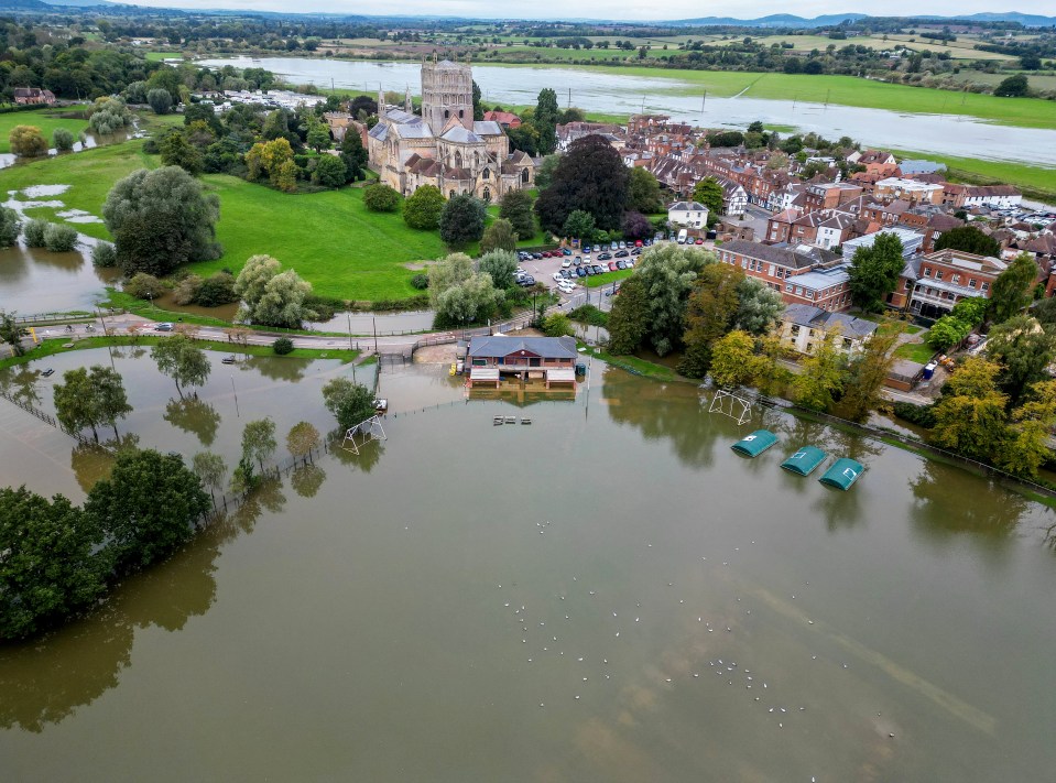 an aerial view of a flooded area with a church in the background