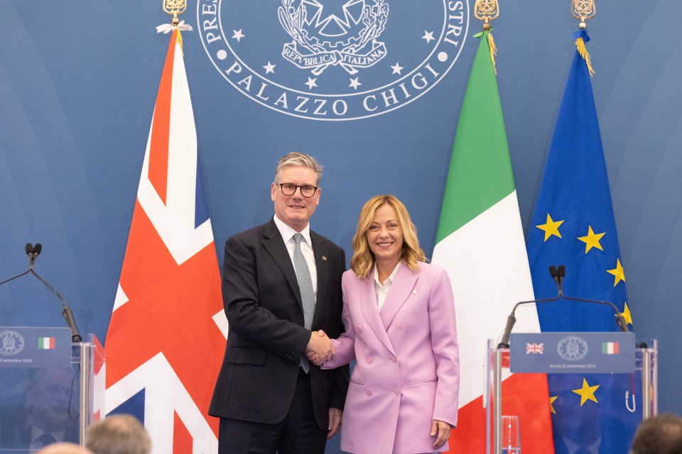 two people shaking hands in front of a sign that says palazzo chigi