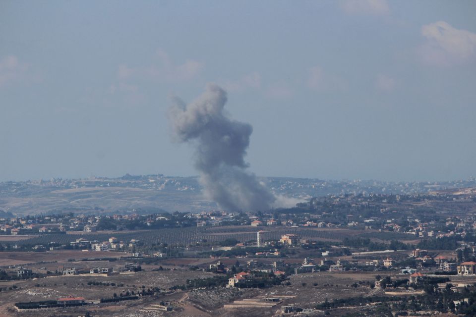 a large smoke stack is visible over a city