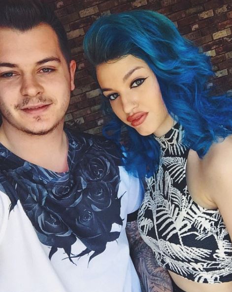 a man and a woman with blue hair are posing for a picture