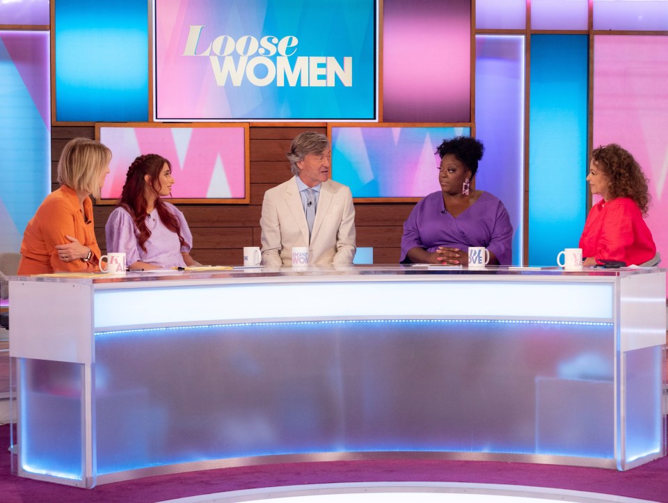 four women are sitting at a table in front of a screen that says loose women