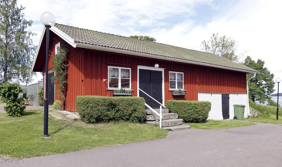 a small red house with a black door and stairs