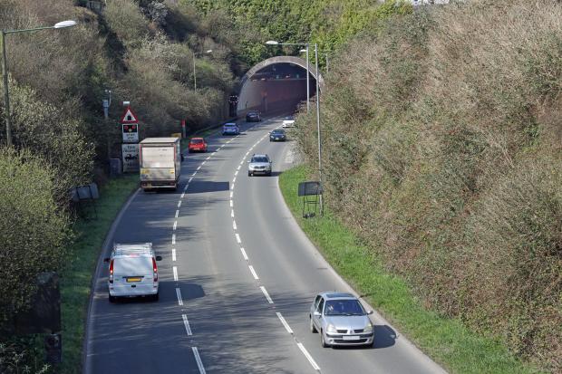 a sign on the side of the road warns of a tunnel