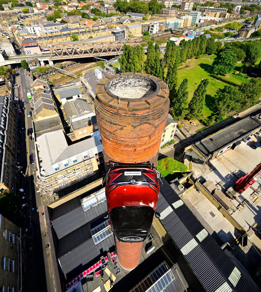 an aerial view of a city with a red car on top of a brick chimney