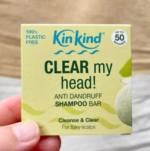 a hand is holding a kin kind clear my head anti dandruff shampoo bar