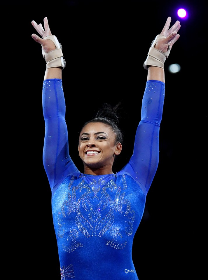 a gymnast wearing a blue leotard with a british flag on it