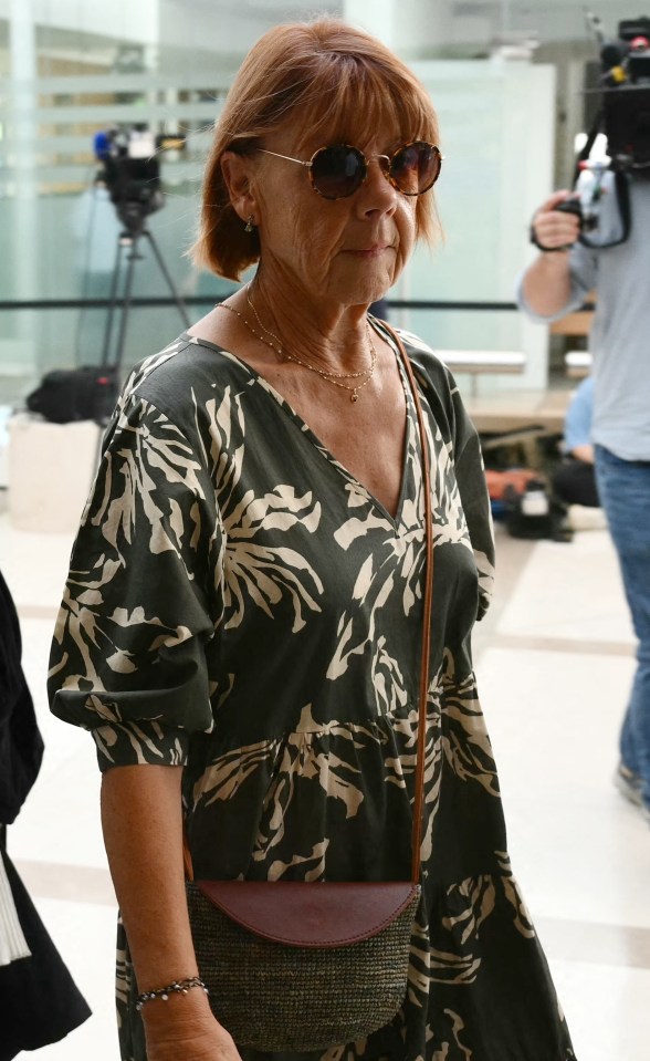 a woman in a floral dress walks through a crowd of people