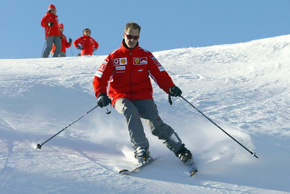 a man skiing down a snowy slope wearing a red jacket that says ferrari on it