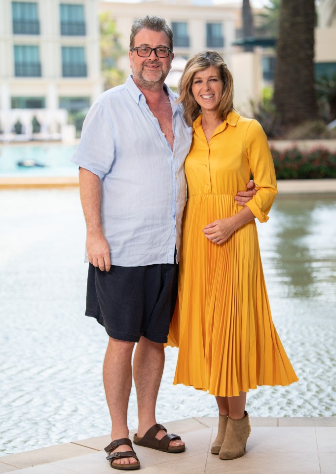 a woman in a yellow dress stands next to a man in a blue shirt