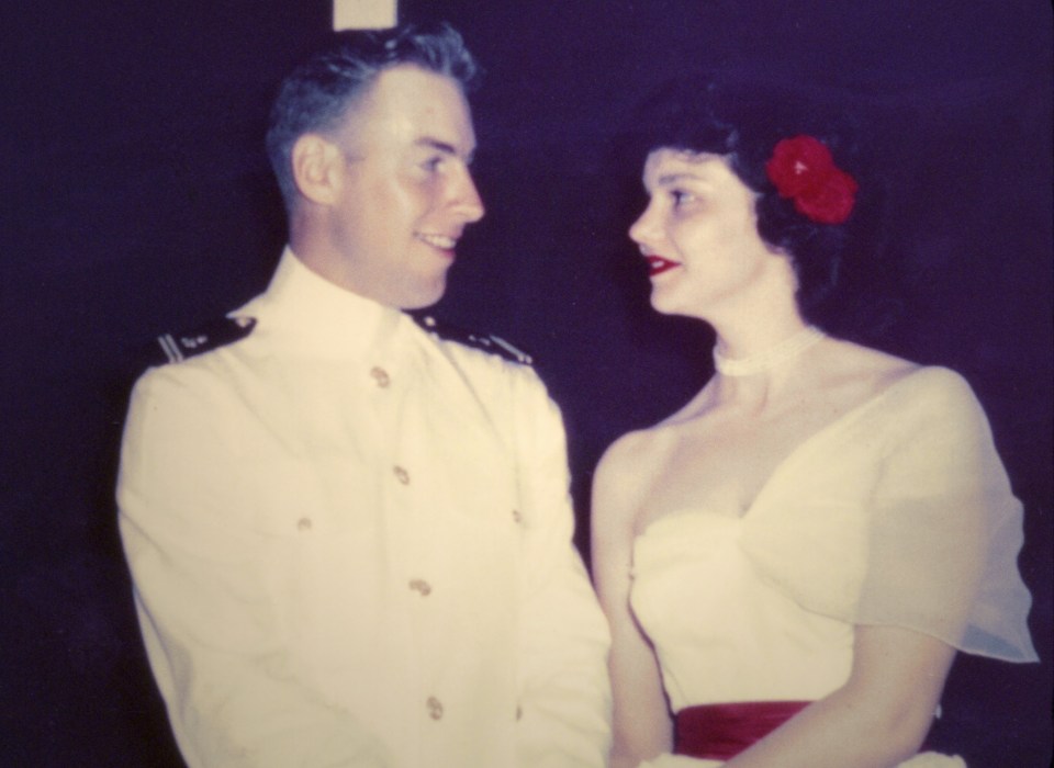 a man in a white uniform and a woman in a white dress are looking at each other