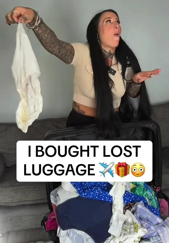 a woman is holding a white cloth in front of a suitcase that says i bought lost luggage