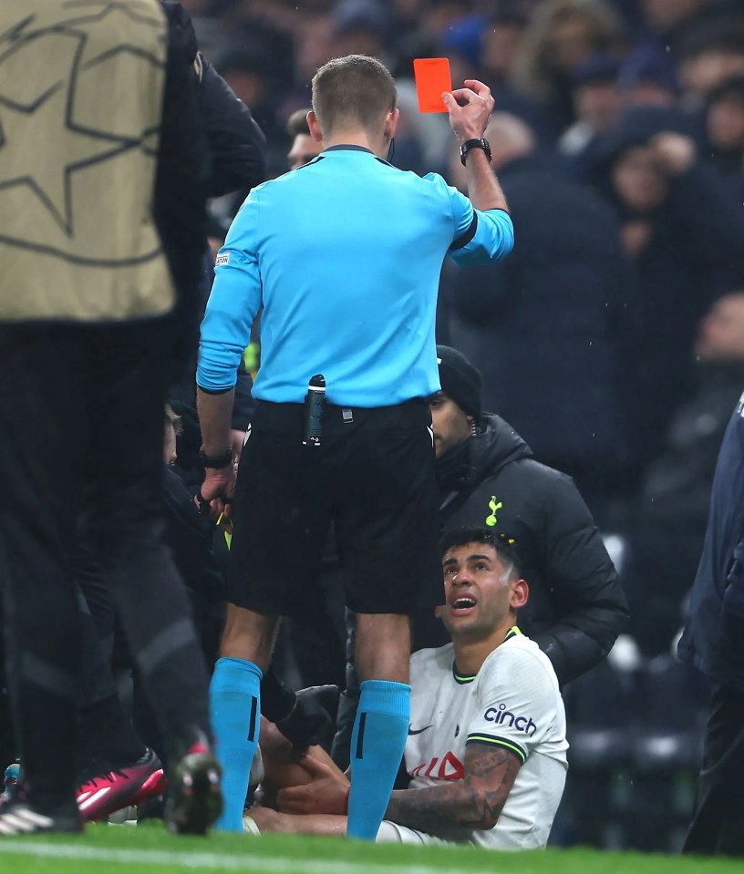 a referee gives a red card to a tottenham player