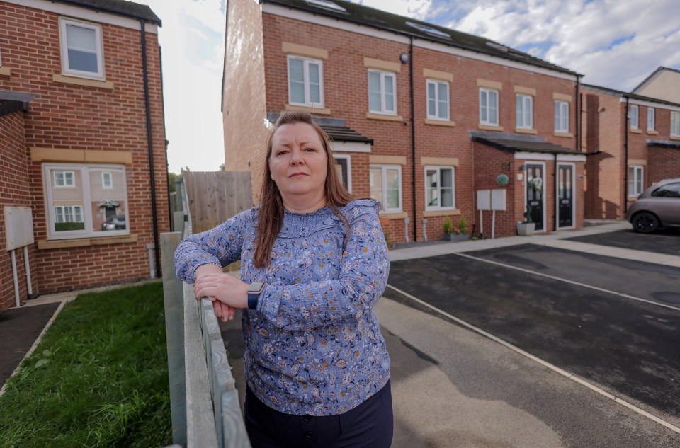 a woman leans on a railing in front of a row of brick houses